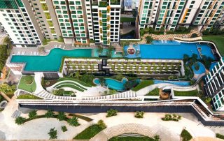 Góc nhìn từ trên cao tại Feliz En Vista Quận 2 cho thấy hệ thống hồ bơi, sân vườn và đường dạo được sắp xếp giữa các tòa căn hộ, kết hợp nhiều mảng xanh trong không gian tiện ích nội khu.