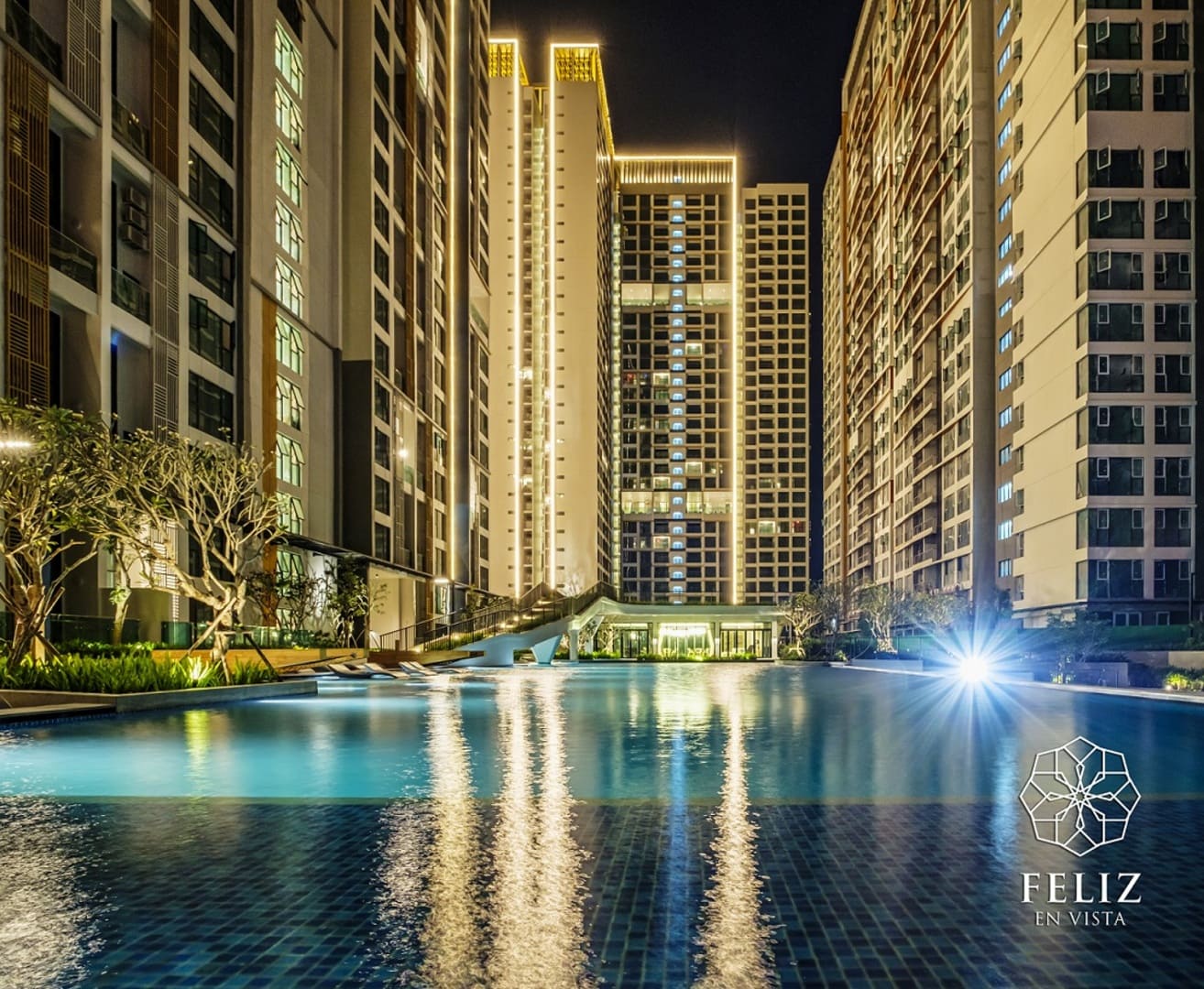 Hồ bơi nội khu Feliz En Vista Quận 2 lung linh dưới ánh đèn vào buổi tối, phản chiếu những tòa căn hộ cao tầng xung quanh, tạo nên khung cảnh thư giãn giữa không gian sinh hoạt hiện đại.