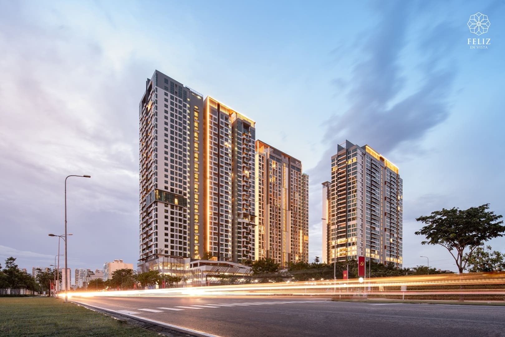 Toàn cảnh các tòa căn hộ Feliz En Vista Quận 2 lên đèn lúc hoàng hôn, nổi bật với kiến trúc cao tầng hiện đại bên tuyến đường lớn, góp phần tạo điểm nhấn cho khu vực Thạnh Mỹ Lợi.